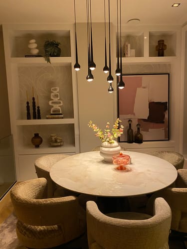 Recensent toont het witte HKliving Sculpture-ornament op een plank in een stijlvol interieur.