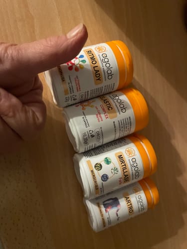 Cliente mostra quattro flaconi di integratori Agolab, tra cui Mirtillase, con un pollice in su.