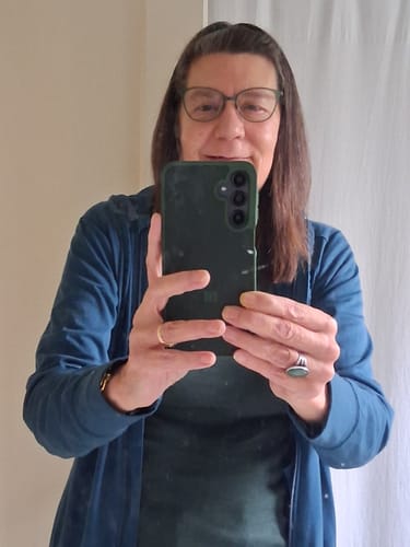 Customer wearing the forest green Hannah Long Sleeve Top as a base layer under a blue top.