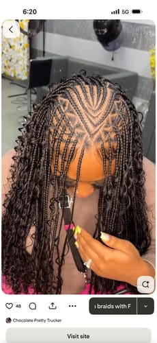Close-up of a customer's Feeding Braid Wig, showing the intricate V-shaped parting and curly ends.