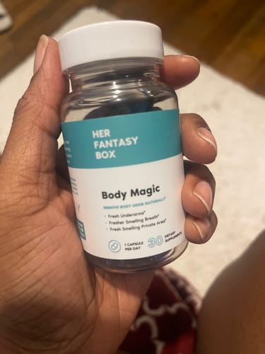 Customer holding a clear bottle of Body Magic pills in their hand, showing the label.