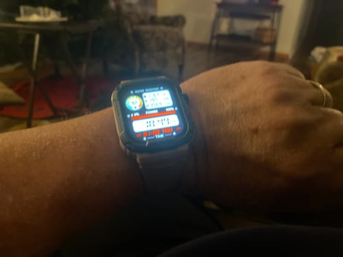 Reviewer's Gard Pro Ultra smartwatch on their wrist, with the detailed, illuminated watch face showing various metrics.