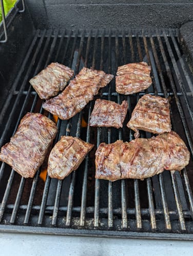 Customer grilling the broken pieces of Skirt Steak on a barbecue.