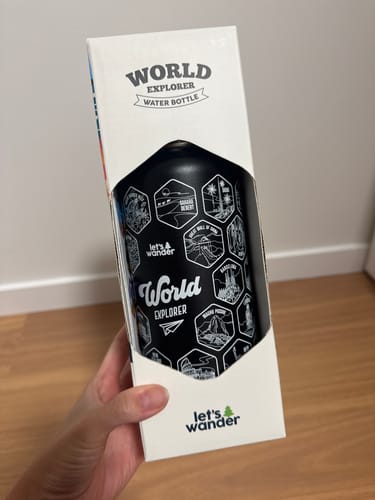 Reviewer holding the black World Explorer Bottle in its original white packaging.