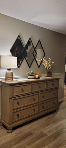 Customer's Black 3 Diamond Metal Mirror mounted on an entryway wall above a wooden dresser.