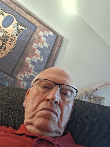 A close-up selfie of the reviewer, an older man in a red shirt.