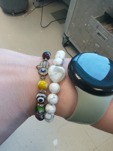 Customer wearing the howlite crystal bracelet with white marbled beads and a heart-shaped bead on their wrist.