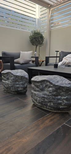 Customer's two Natural Stone Benches used as unique seats on a modern patio.