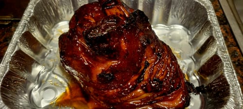 Reviewer's large glazed meat, cooked with Killer Bee Honey Rub, sitting in a foil pan.