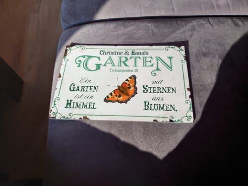 Kundenbild eines personalisierten „Gartenglück“-Türschilds mit Namen, Spruch und Schmetterling-Motiv.