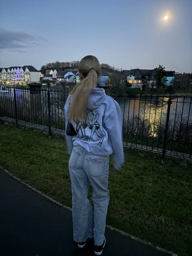 Reviewer from behind wearing the oversized after party grey hoodie, showing the back graphic print.