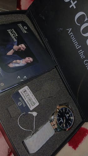 Customer's Sveston Stupendous watch with a dark dial and stainless steel strap, shown inside its black gift box.