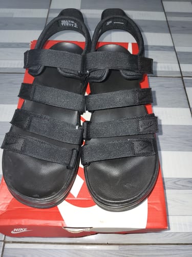 Customer's pair of black Nike Icon Classic Sandals with multiple straps, shown on top of the shoebox.