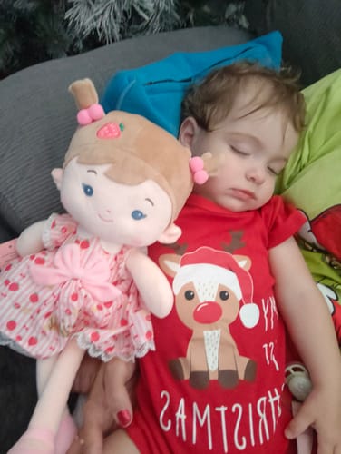 Customer's toddler sleeping soundly on a couch next to the Personalized Strawberry Girl doll.