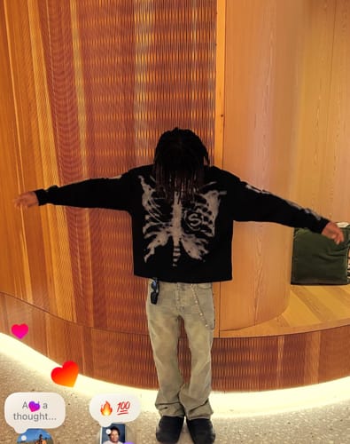 Reviewer posing indoors to show the fit of the light-wash Checkerboard Distressed Jeans.