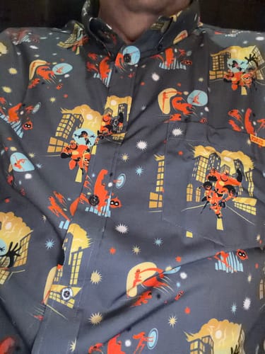 Close-up of a reviewer wearing the Incredibles "Metroville's Most Wanted" shirt, showing the colorful character and city pattern.