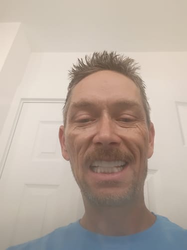 Customer smiling, showing a full, bright white set of Pop On Veneers.
