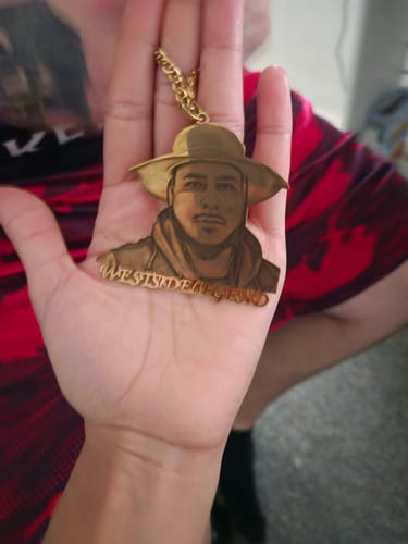 Reviewer holding their custom photo engraved pendant in their palm, showing the detailed portrait.