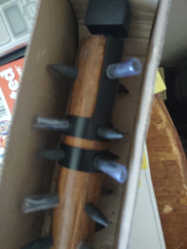 Close-up: A customer's Thumper spiked club in its box, showing the wooden head and dark metal spikes.
