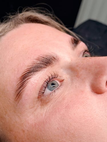 Close-up of a reviewer's sleek, laminated brow and lifted lashes after using the Cysteamine Lamination Kit.
