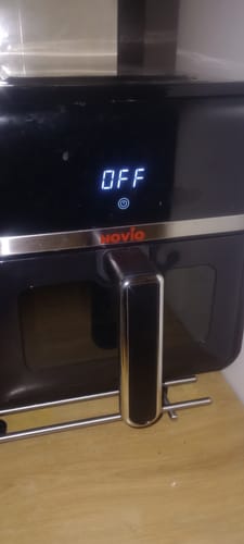 Prim-plan cu friteuza Air Fryer Novio StonePro neagră a unui client, cu ecranul digital afișând mesajul „OFF”.