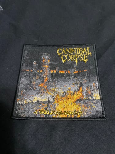 Customer's Cannibal Corpse 'A Skeletal Domain' embroidered patch lying flat on a dark surface.