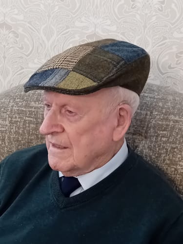Customer wearing the Donegal Touring Cap, showing off its unique patchwork tweed design.