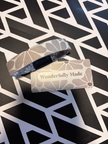 Reviewer's Wonderfully Made Bible Verse Bracelet with a floral pattern, shown with its matching packaging card on a geometric surface.