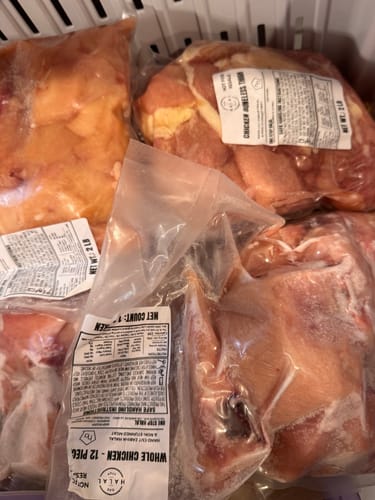 Customer's various packaged Halal Chicken products, including breast and thighs, stored in a freezer basket.