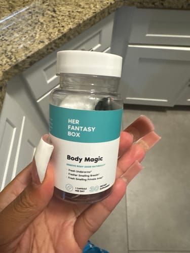 A reviewer holds a clear bottle of Body Magic Chlorophyll Pills in their hand.