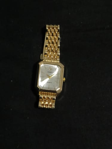 Customer's CLAIRE DE MAINS watch in gold, showing its rectangular face and classic link band on a dark surface.