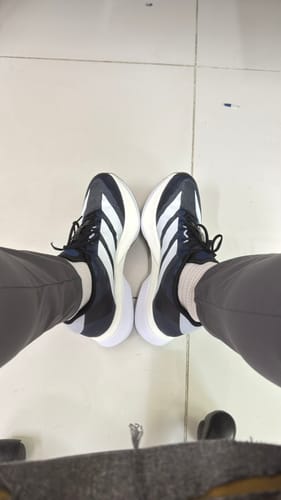 Customer's view looking down at their adidas Adizero Boston 13 Running Shoes in dark blue and white.