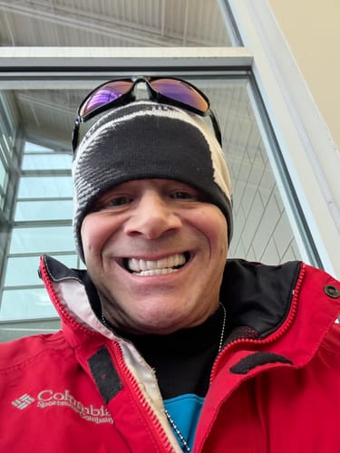 Customer smiling broadly to showcase their bright white Pop On Veneers while wearing a red jacket and beanie.
