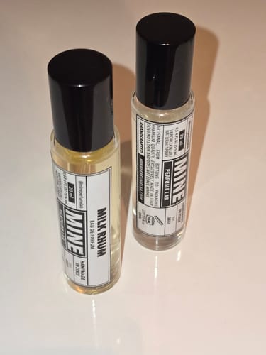 Cliente mostra due piccoli flaconi in vetro del profumo MILK RHUM.