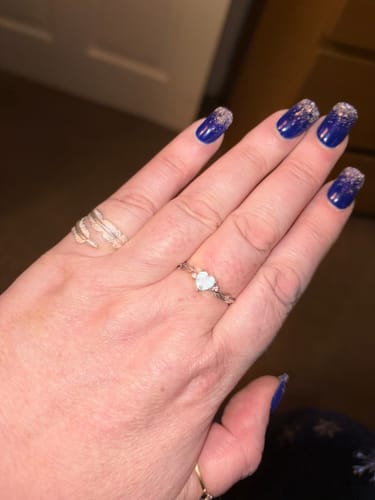 Reviewer's hand wearing the silver Feather From An Angel Ring, which wraps around the index finger.
