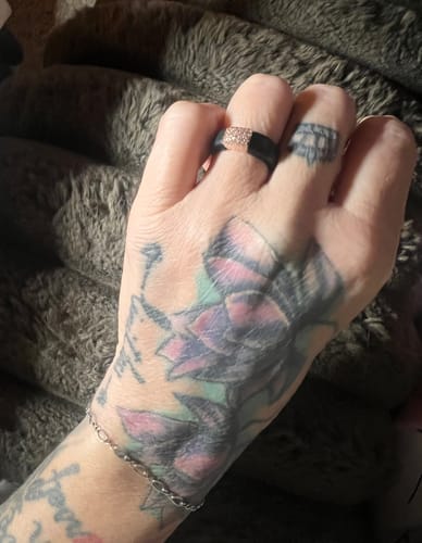 Customer wearing the black silicone ring with a sparkly, rose-gold colored metal and stone setting.