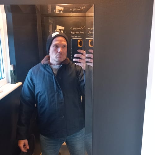 Customer takes a mirror selfie wearing the navy N-1 Woolen Deck Jacket indoors.