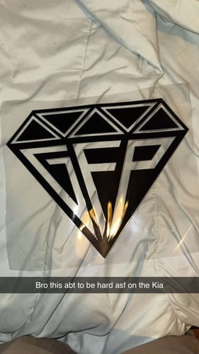 Customer's black, diamond-shaped GFP Premium Decal on its transfer sheet, laid on a fabric surface.