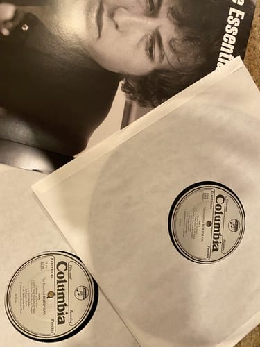 Reviewer shows the contents of a gift-wrapped album, revealing two identical Bob Dylan records.