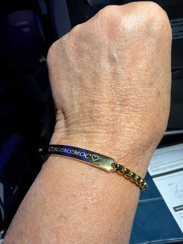 Reviewer's wrist showing the shiny, engraved Round Box ID Bracelet with initials and hearts.