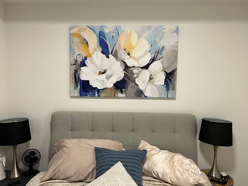 Customer's 'Abstract Flower' Framed Canvas hanging on a bedroom wall above a grey tufted headboard.