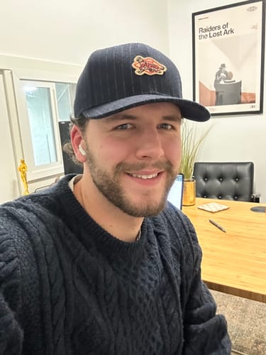 Reviewer smiling in an office while wearing the dark Structured Wool Patterned Hat, showing a good fit.