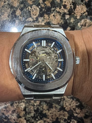 A reviewer's close-up of their silver-colored Lucky Fours® Skeleton watch on their wrist.
