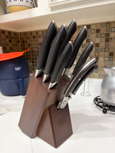 Customer's 9-Piece Chef Knife Set with dark handles in its wooden block on a kitchen counter.