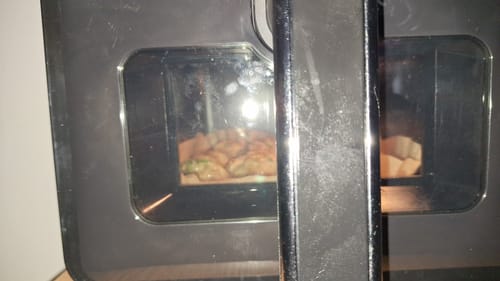 Vedere apropiată de la un client a friteuzei Novio StonePro în timp ce gătește alimente în interior.