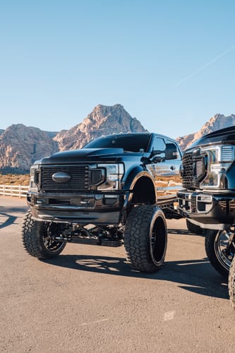 Customer's digital wallpaper of a large black truck with lifted suspension and mountains in the background.