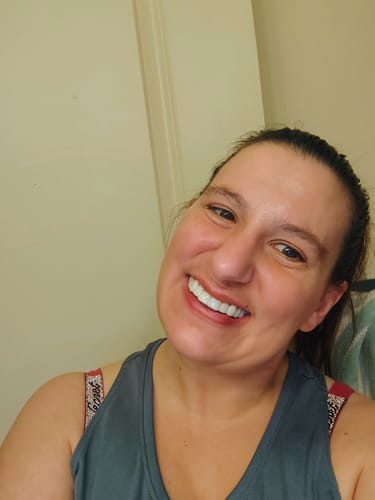 Customer showing a happy smile while wearing her perfectly white Spare Veneers.