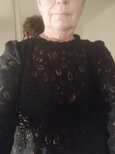 Gros plan d'une cliente portant la Blouse Fantine en délicate dentelle noire.
