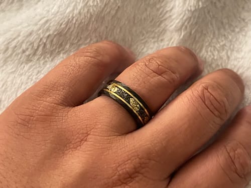 Close-up of a customer's hand wearing the black Titanfall ring, showing its meteorite and gold flake inlay.
