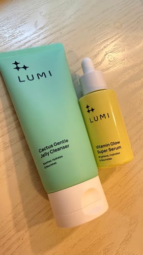 Customer's Jelly Cleanser and Vitamin Glow Super Serum duo, showing the green tube and yellow bottle on a wooden surface.